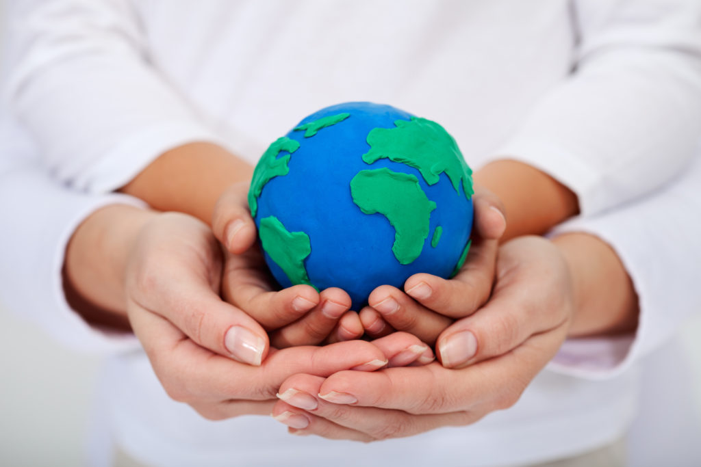 Our legacy to the next generations - a clean environment, with child and adult hands holding earth globe